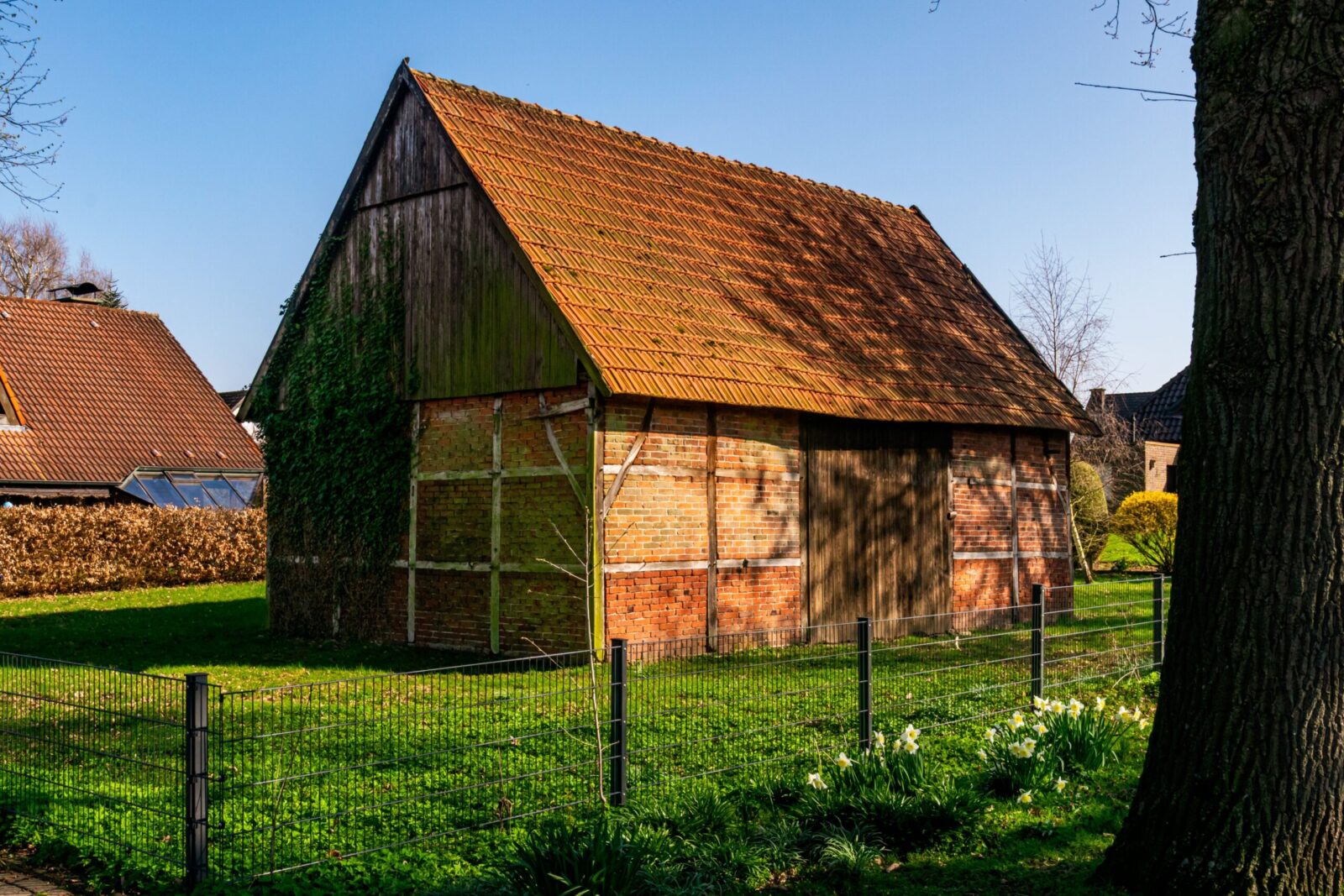 Rustic brick barn surrounded by spring greenery in Coesfeld, Germany.